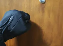 Mężczyzna w rękawiczkach i garniturze pukający do drzwi mieszkania. Fot. Warszawa w Pigułce