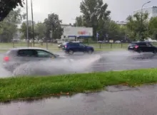 Ulewa w mieście. Samochody i autobusy rozpryskują wodę na boki