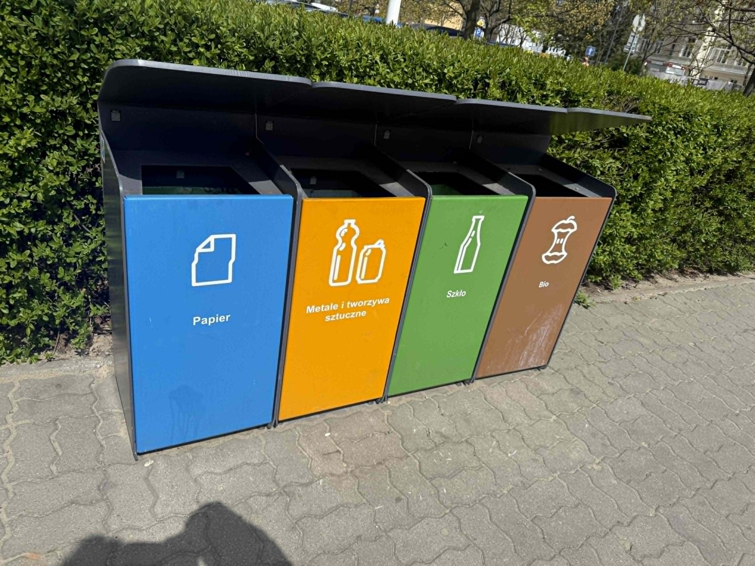 Kosze na śmieci stojące na chodniku fot. Warszawa w Pigułce