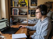 Uczeń uczy się na lekcji biologii na zajęciach zdalnych w swoim pokoju