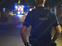 Akcja straży pożarnej. Na pierwszym planie policjant zabezpieczający miejsce zdarzenia.