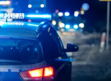 Radiowóz stojący z innymi służbami na drodze. | Fot. FotoDax / Shutterstock.