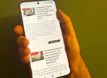 Smartfon na ekranie którego widać stronę główną serwisu Warszawa w Pigułce.
