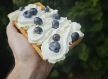 Gofr z bitą śmietaną i borówkami amerykańskimi.