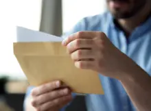 Młody mężczyzna czyta listy.