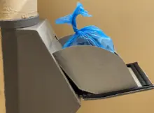 Otwarty zsyp w bloku. W środku włożona jest reklamówka.